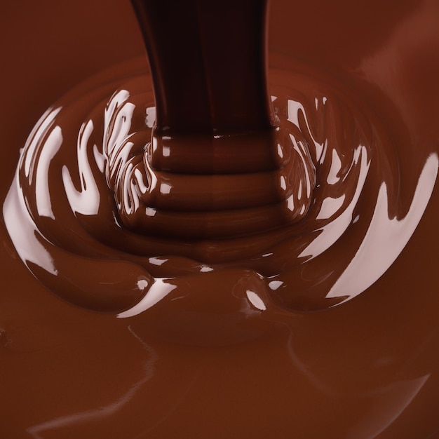 Liquid dark chocolate flowing sweet dessert background