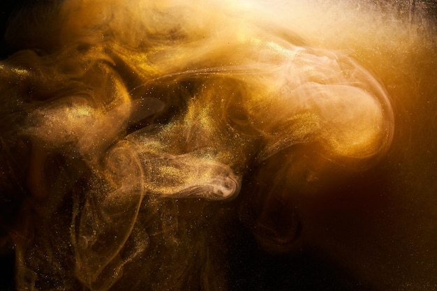 Liquido fluido arte sfondo astratto getti ocra e anelli di fumo che ballano vernici acriliche spazio subacqueo esplosione di colore dell'oceano