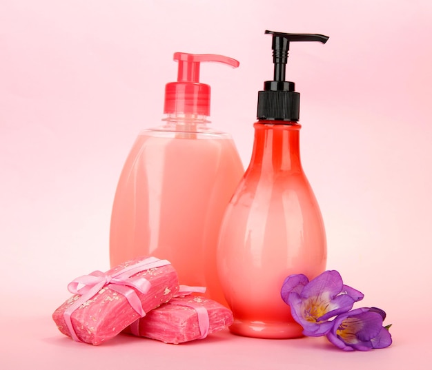 Liquid and handmade soaps on pink background