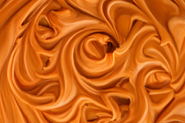 Liquid melted caramel syrup Background of caramel syrup paste Curl wave of caramel Texture