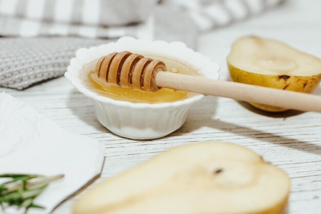 Liquid organic honey in white bowl wooden honey spoon