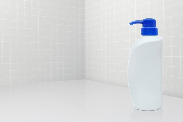 Bottiglia di sapone liquido con sfondo piastrellato accessori per il bagno