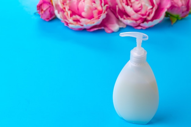 Liquid soap in clear bottle on color background, close up