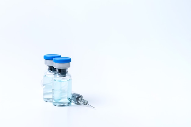 Liquid vaccine vial bottle and syringe preparing for injection isolated on white background