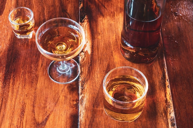 Liquor  glass and liquor bottles on wooden table