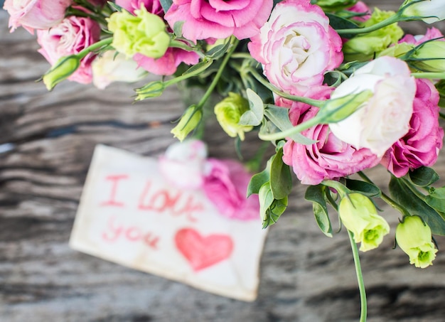 Photo lisianthus bouquet on a wooden table with message i love you