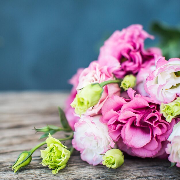 나무 테이블에 Lisianthus 꽃다발