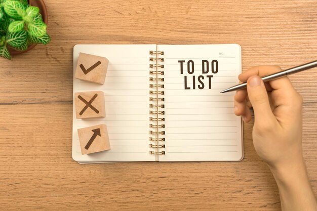 To do list concept. wooden table background with empty\
notebook. planning for new year, goal list, strategy. top view\
photo