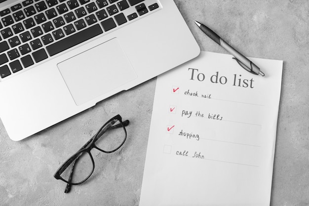 To-do list with laptop on grey