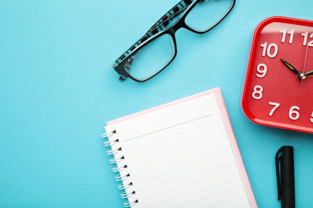 To do list written in a notebook Notebook with an to do list on blue with cup of coffee and clock