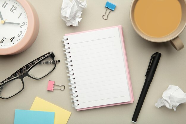 To do list written in a notebook notebook with an to do list on\
grey with cup of coffee and clock