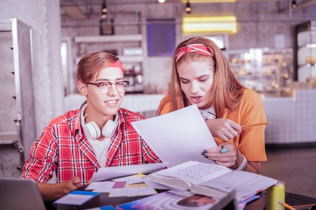 Listen to me. attentive girl bowing head while staring at paper
sheet