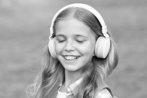Listen music while walking Girl headphones listening music Educational podcast Kid girl enjoy music Pleasant time Child headphones listen music Audio book concept Studying audio lessons