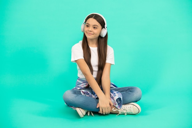 음악 무선 헤드셋 장치 액세서리 새로운 기술 어린 시절 개발 어린이 현대 이어폰 온라인 교육을 듣습니다. 헤드폰을 끼고 학교로 돌아가는 행복한 10대 소녀