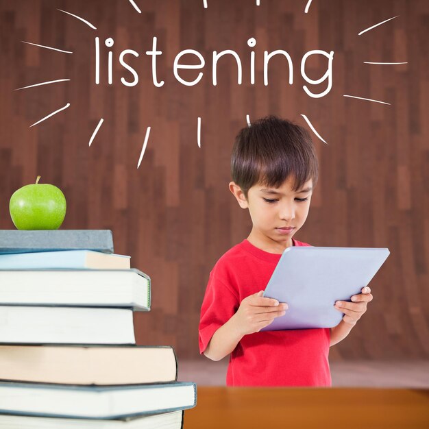 Listening against red apple on pile of books