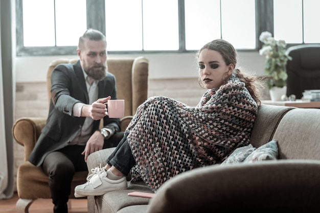 Not listening. Appealing stressed teenage daughter with dark makeup not listening to her father