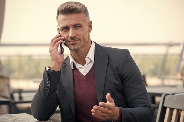Listening call partner businessman hold mobile phone handsome\
man with phone outdoors mobile lifestyle mobile negotiations\
business communication online communication modern\
communication