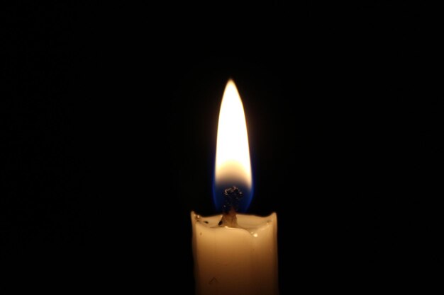 Photo lit candle against black background