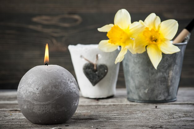 Lit candle and yellow flowers