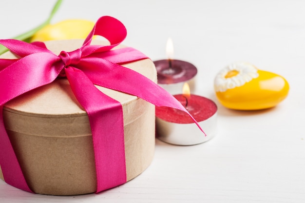 Photo lit candles and gift box with red ribbon