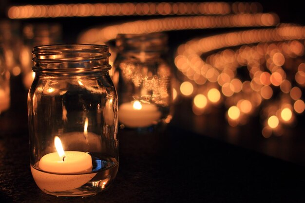 Фото Зажженные свечи в банку на стене ночью