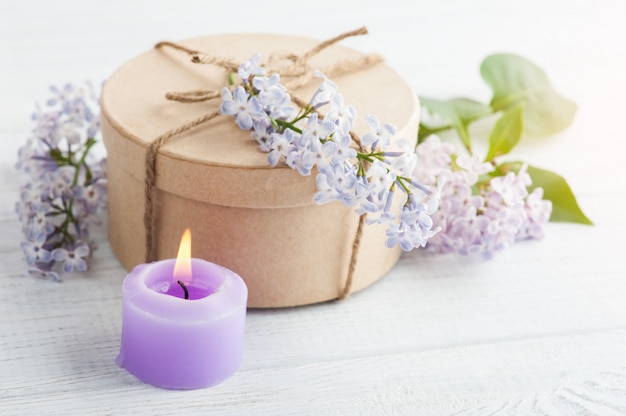 Lit purple candle and lilac flowers