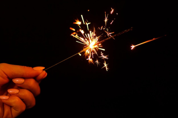 A lit sparkler showing bright sparks