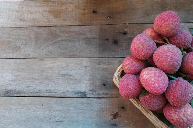 Litchi chinensis of lychee, fris een lychee in rieten mand op oud hout, landelijke stijl.