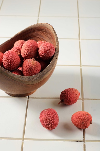 Litchi, Lichee, Lychee 또는 Lichi, 나무 그릇에 신선한 리치 과일과 흰색 배경, 절연, 선택적 초점 그림.