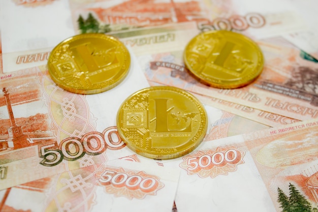 Фото Криптовалюта litecoin монета на банкнотах 5000 российских рублей крупным планом. криптовалюта golden ltc.
