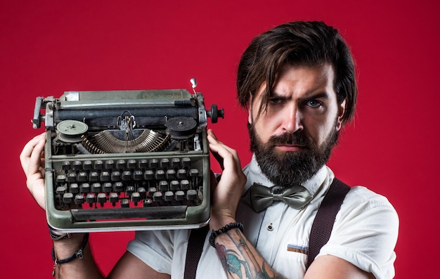 Literatuur en poëzie oude technologie in het moderne leven ouderwetse bebaarde hipster trendy man in vlinderdas gebruik retro typemachine zelfverzekerde en elegante man met vintage apparatuur