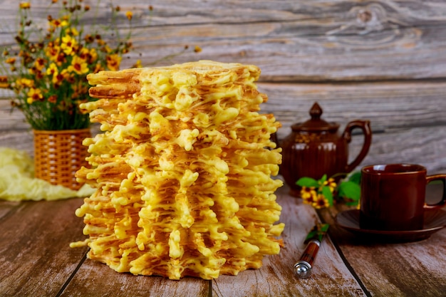 Photo lithuanian traditional layered cake sakotis with tea on wooden surface.