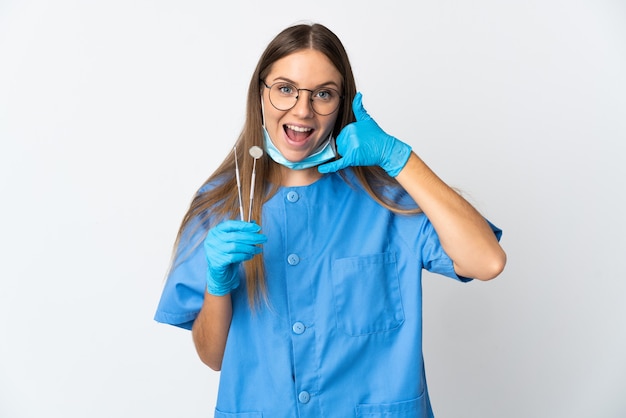 Foto dentista lituano della donna che tiene gli strumenti sopra isolato che fa gesto del telefono. richiamami segno