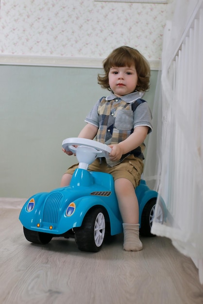 Litle boy sit on a toy car