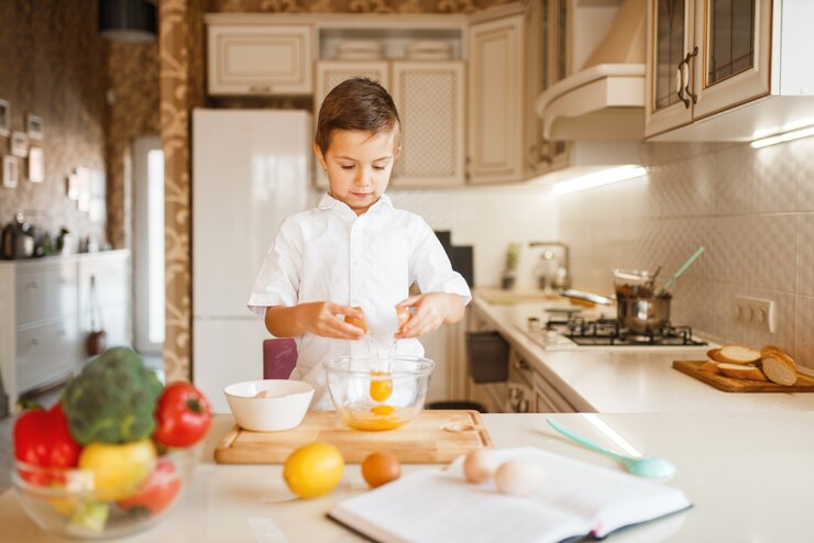 Photo litte boy stirs raw eggs in a bowl