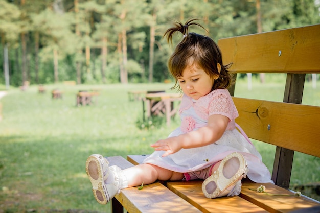 little 2 year old girl in a park near a forest