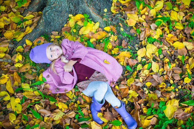 Little adorable girl in autumn park on sunny fall day