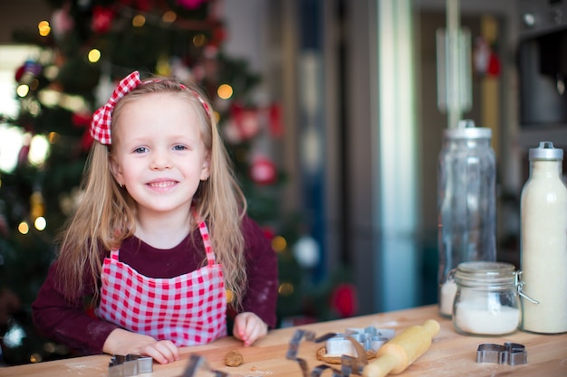 Little adorable girl baking Christmas cookies at home