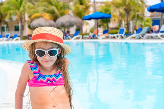 Little adorable girl in outdoor swimming pool