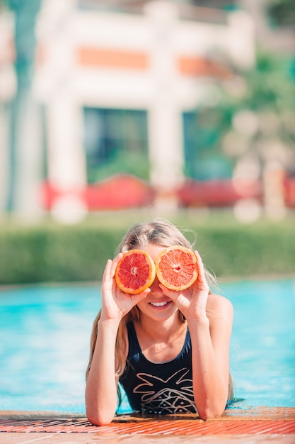 Little adorable girl in outdoor swimming pool