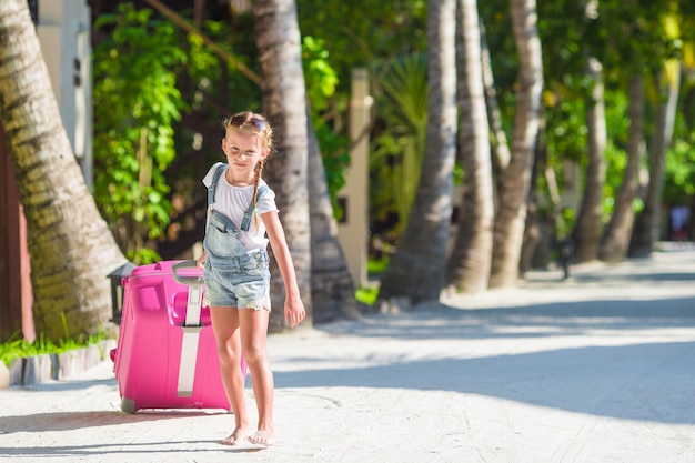 Piccola ragazza adorabile con grande bagaglio durante le vacanze estive