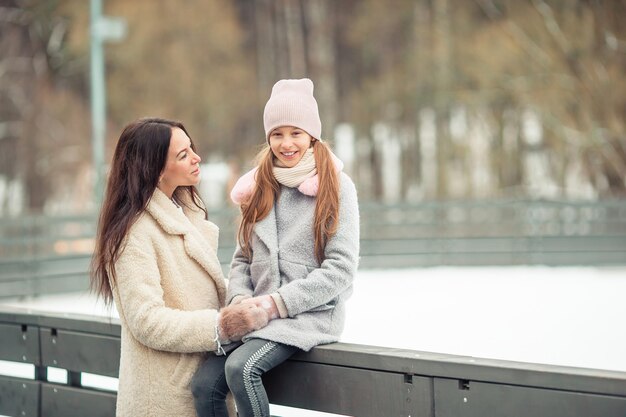 Photo little adorable girl with her mother skating on ice-rink