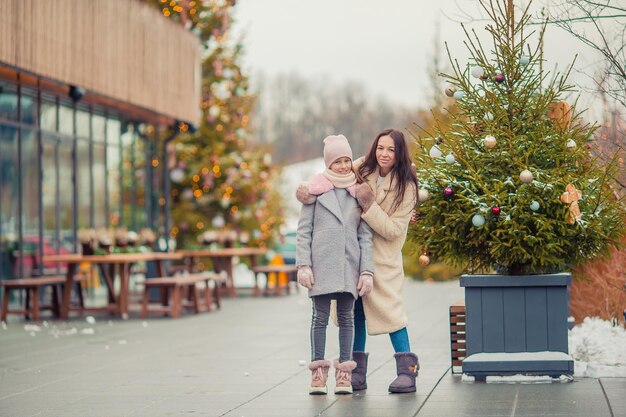 Little adorable girl with her mother skating on ice-rink