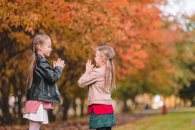 Little adorable girls outdoors at warm sunny autumn day