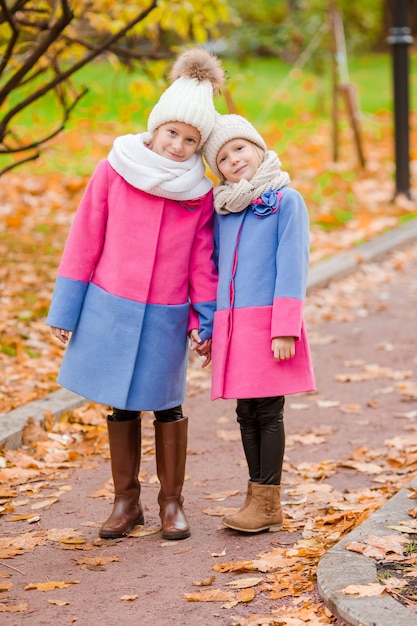 Little adorable girls outdoors at warm sunny autumn day