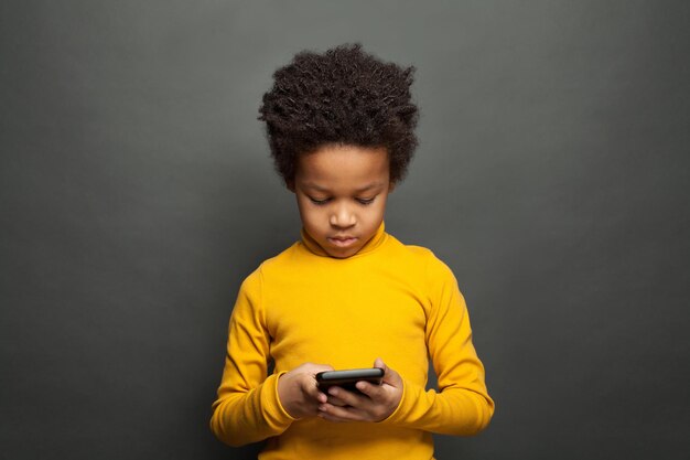 Little African American child using smartphone