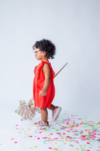 little African American girl in red summer clothes on a white background in the studio