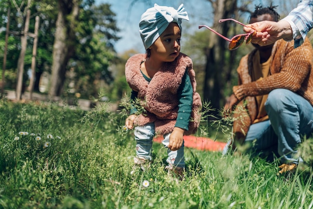 Piccola ragazza afroamericana sorridente e giocando nel parco