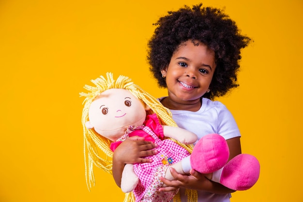 Little afro girl holding a rag doll