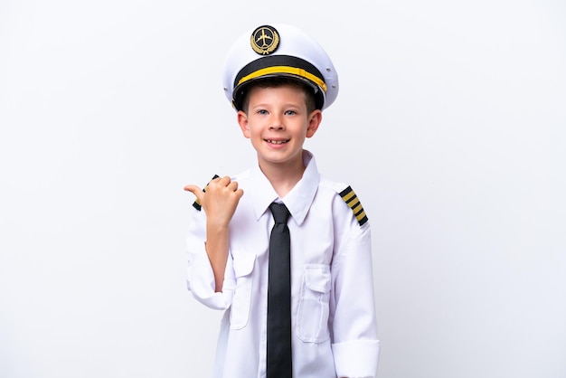 Little airplane pilot boy isolated on white background pointing to the side to present a product